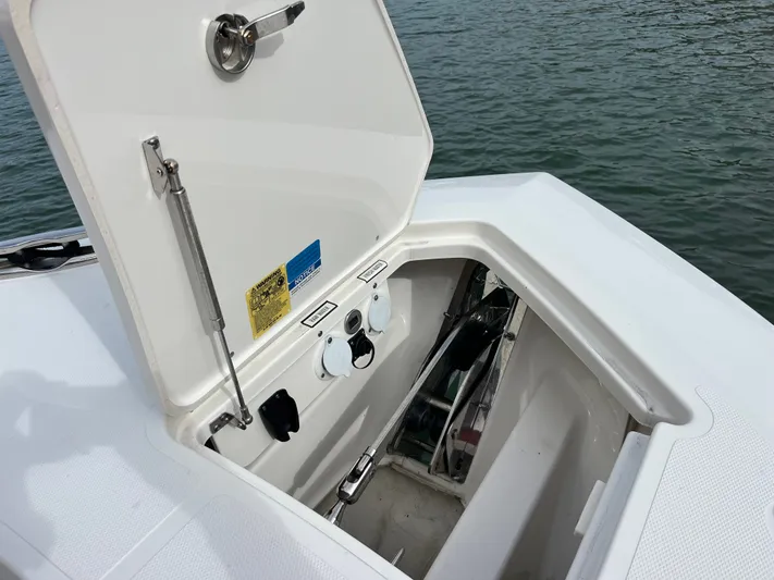  Yacht Photos Pics Open storage compartment on 2024 Pursuit 358 SPORT boat, showing interior details by the water.