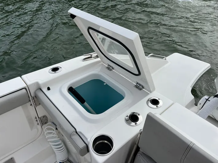  Yacht Photos Pics Open hatch on 2024 Pursuit 358 SPORT boat, revealing storage compartment by the water.