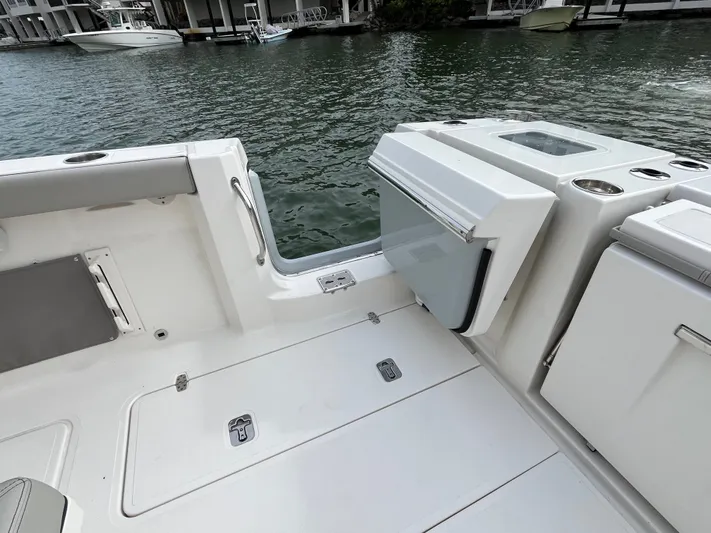  Yacht Photos Pics 2024 Pursuit 358 SPORT boat interior with open storage compartment, dockside view.