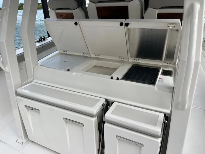  Yacht Photos Pics 2024 Pursuit 358 SPORT boat interior with open storage compartments and seating.