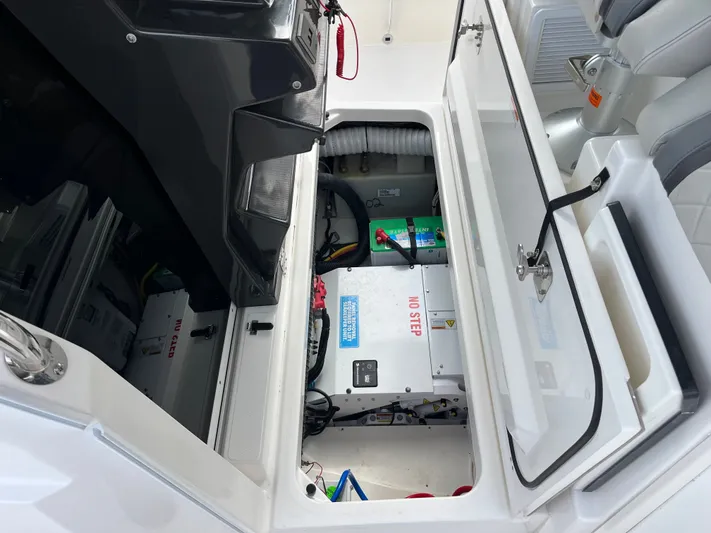  Yacht Photos Pics 2024 Pursuit 358 SPORT boat interior showing open storage compartment with battery and equipment.