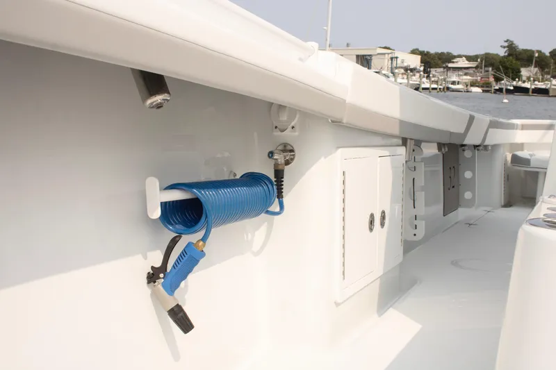  Yacht Photos Pics 2025 Yellowfin 32 Offshore boat deck with coiled blue hose and storage compartments.