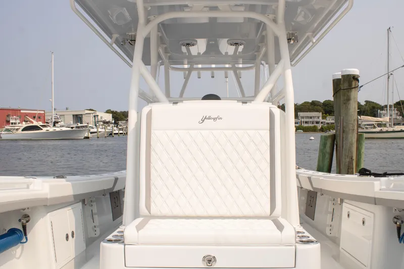  Yacht Photos Pics 2025 Yellowfin 32 Offshore boat interior with white seating, docked at a marina.