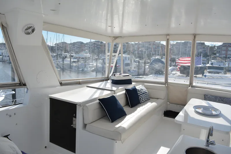 Lady Laura Yacht Photos Pics Interior of 1989 Viking Motor Yacht with white seating and marina view.