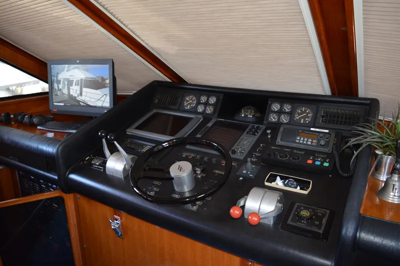 Lady Laura Yacht Photos Pics Control panel of a 1989 Viking Motor Yacht with steering wheel and navigation equipment.