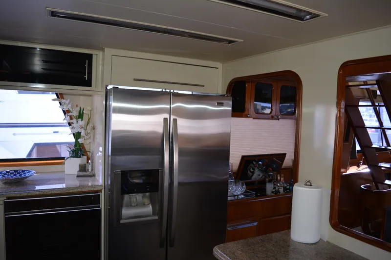 Lady Laura Yacht Photos Pics Interior of 1989 Viking Motor Yacht kitchen with stainless steel appliances and wooden cabinetry.