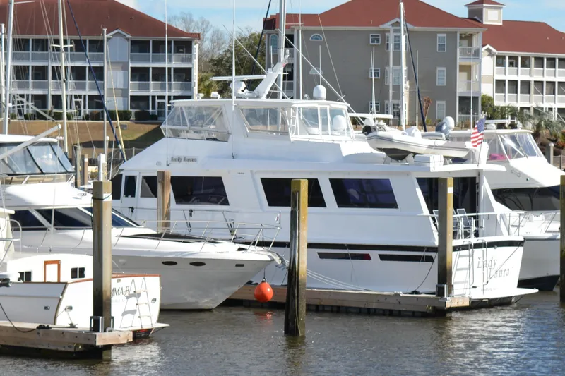 Lady Laura Yacht Photos Pics 1989 Viking Motor Yacht docked at marina with nearby boats and waterfront buildings.