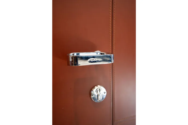  Yacht Photos Pics Chrome handle on Riva Dolceriva 48 yacht, 2019 model, against brown background.