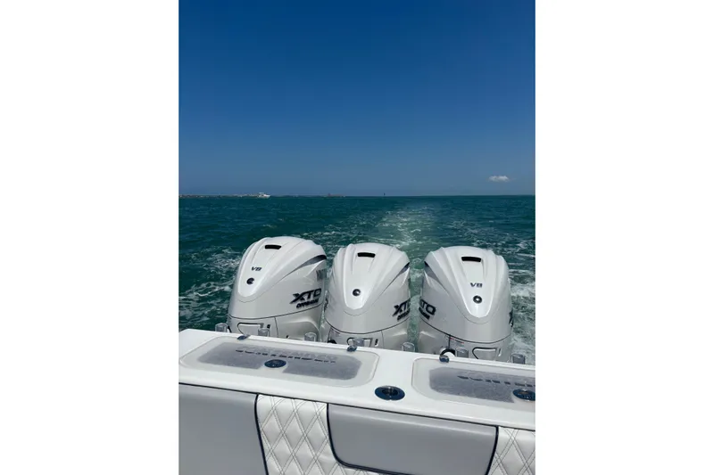  Yacht Photos Pics 2025 Contender 39 ST boat with triple outboard engines cruising on open water.