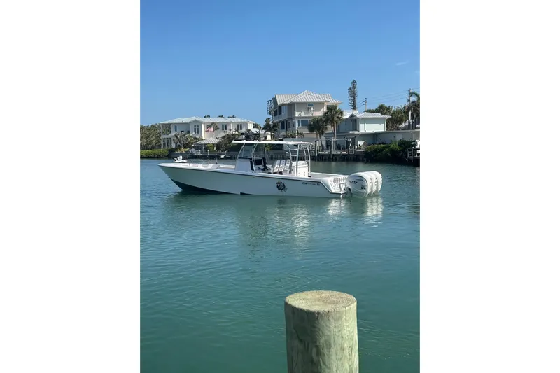  Yacht Photos Pics 2025 Contender 39 ST boat on calm water near waterfront homes.