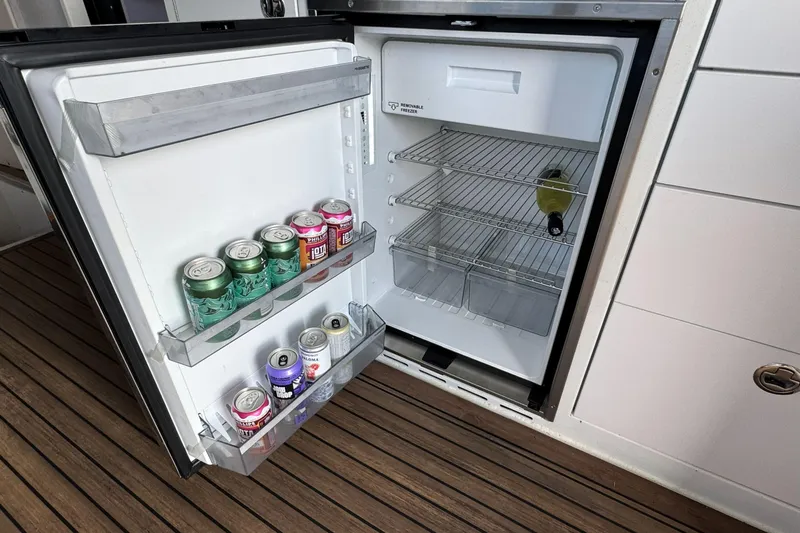  Yacht Photos Pics Open fridge on JR Marine 33 Savage 2025 boat, stocked with drinks on wooden deck.