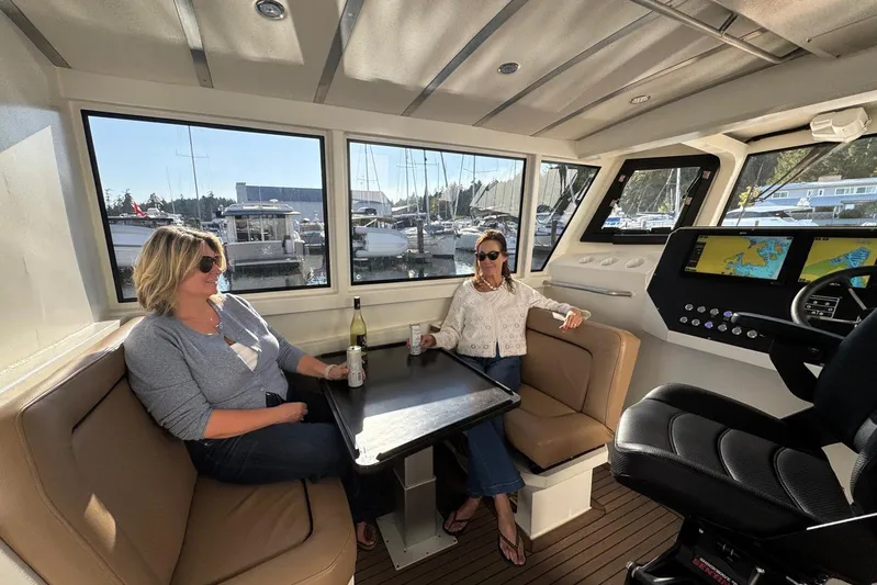  Yacht Photos Pics Interior of 2025 Custom JR Marine 33 Savage with two people relaxing, marina view.
