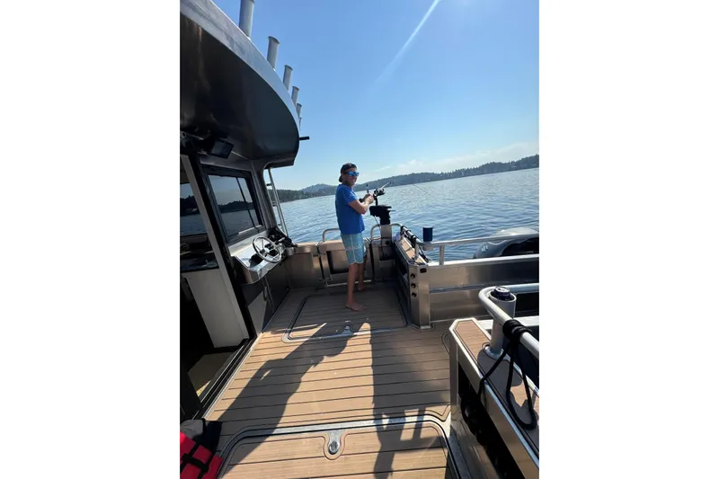  Yacht Photos Pics Man fishing on a 2025 JR Marine 33 Savage boat under clear blue skies.
