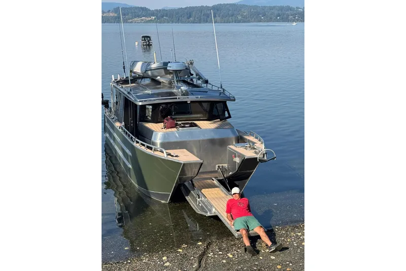  Yacht Photos Pics 2025 JR Marine 33 Savage boat docked on a calm lake with a person relaxing.