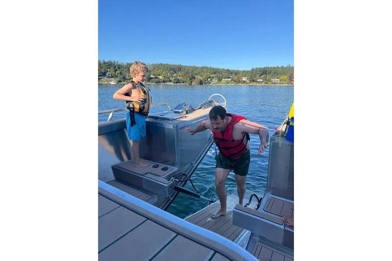  Yacht Photos Pics Man and child in life vests on JR Marine 33 Savage boat, 2025 model, enjoying water activities.