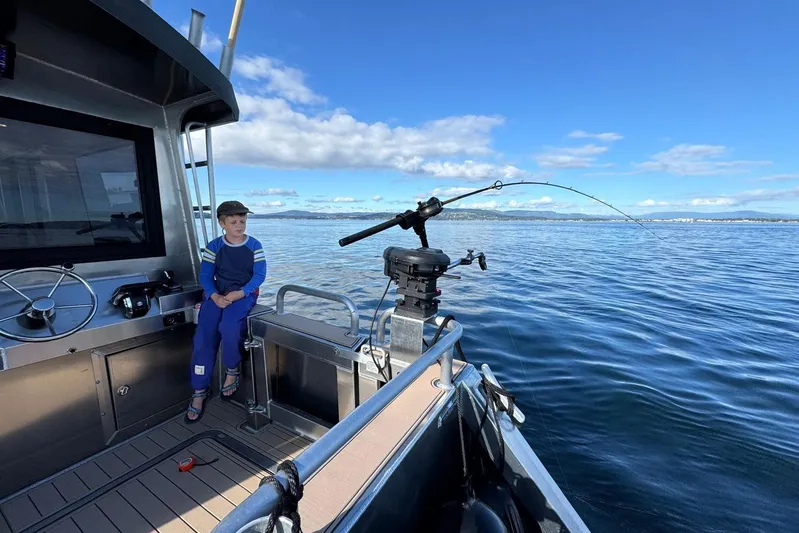  Yacht Photos Pics Boy on JR Marine 33 Savage boat, 2025, fishing on calm blue waters.
