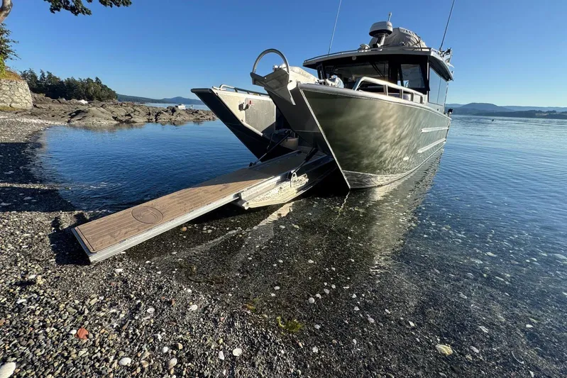  Yacht Photos Pics 2025 JR Marine 33 Savage boat with ramp on rocky shoreline.