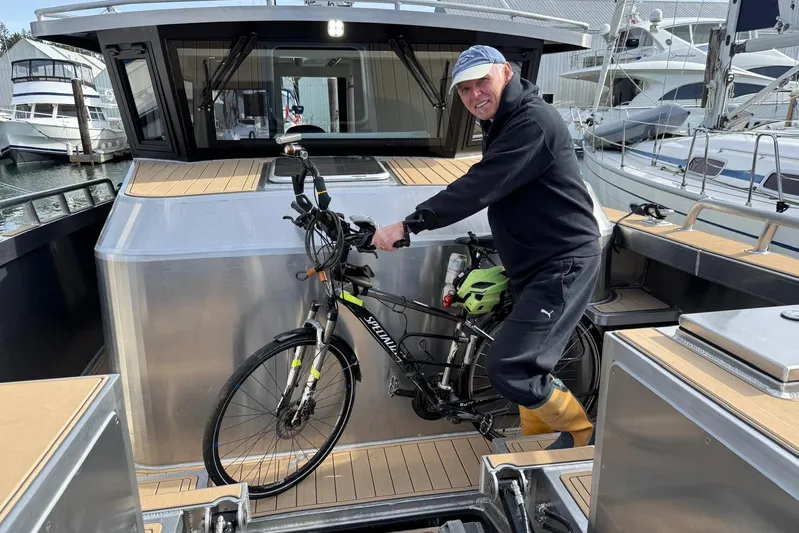  Yacht Photos Pics Man with bicycle on JR Marine 33 Savage boat, 2025 model, docked at marina.