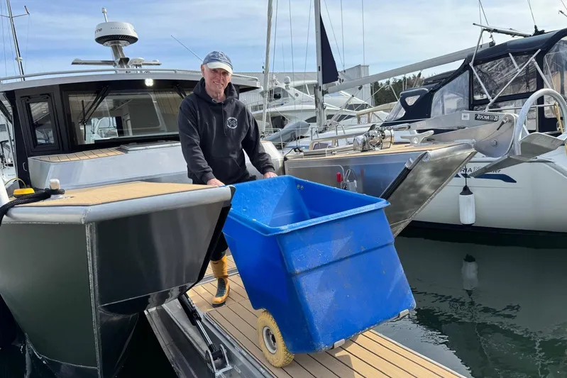  Yacht Photos Pics Man with blue bin on dock beside 2025 JR Marine 33 Savage boat.