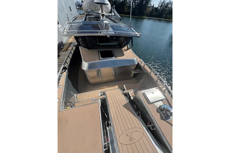  Yacht Photos Pics 2025 JR Marine 33 Savage boat with sleek deck design, docked by the water.