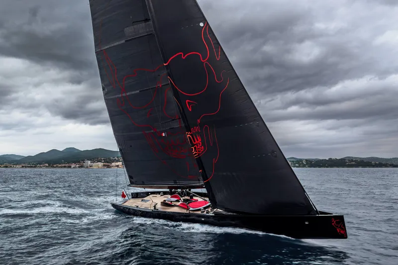 Black Sails Yacht Photos Pics Sleek 2009 Wally 130 yacht with black sails and red skull design on stormy sea.