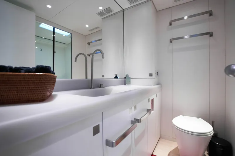 Black Sails Yacht Photos Pics Modern yacht bathroom with sleek white fixtures, large mirror, and basket on counter. Wally 130, 2009.