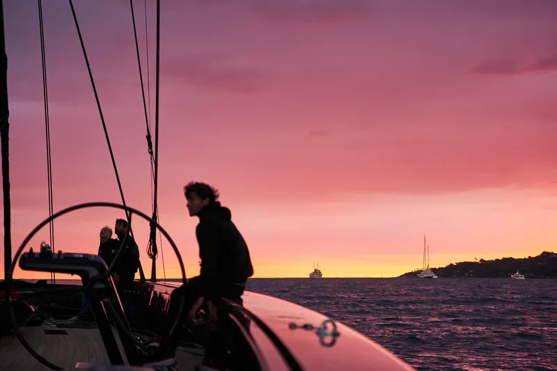 Black Sails Yacht Photos Pics Sailing at sunset on a 2009 Wally 130 yacht, vibrant pink sky.