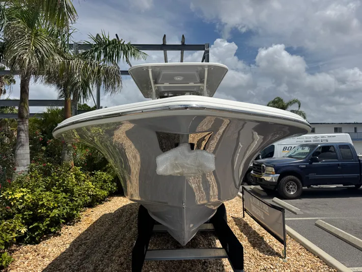  Yacht Photos Pics 2025 Key West 260 boat displayed outdoors, surrounded by palm trees and parked vehicles.
