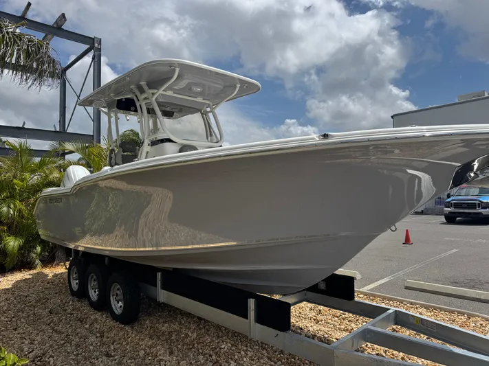  Yacht Photos Pics 2025 Key West 260 boat on trailer, parked outdoors under a partly cloudy sky.