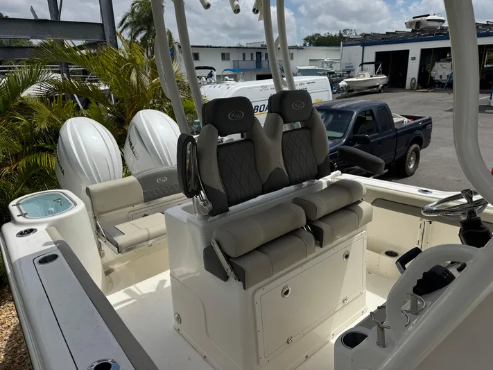 Yacht Photos Pics 2025 Key West 260 boat interior with dual seats and twin engines, parked outdoors.