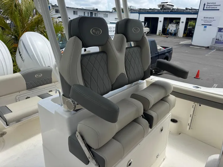  Yacht Photos Pics 2025 Key West 260 boat seats with gray upholstery and armrests in a marina setting.