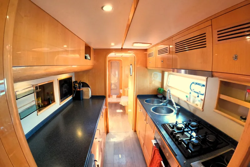 Audaz Yacht Photos Pics Luxurious 2007 Privilege 615 yacht kitchen with modern amenities and sleek wooden cabinetry.