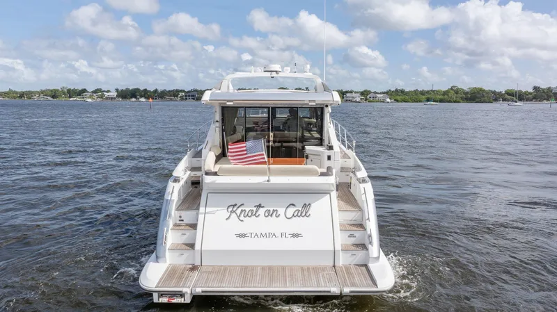 Knot On Call Yacht Photos Pics Azimut 55S 2015 yacht on water, rear view with American flag, "Knot on Call" name.