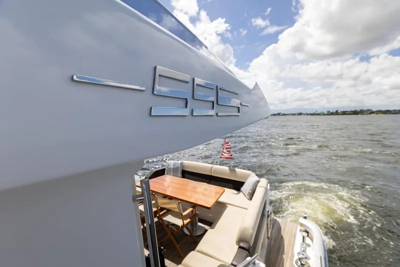 Knot On Call Yacht Photos Pics Azimut 55S 2015 yacht, rear view with seating area, on open water under cloudy sky.