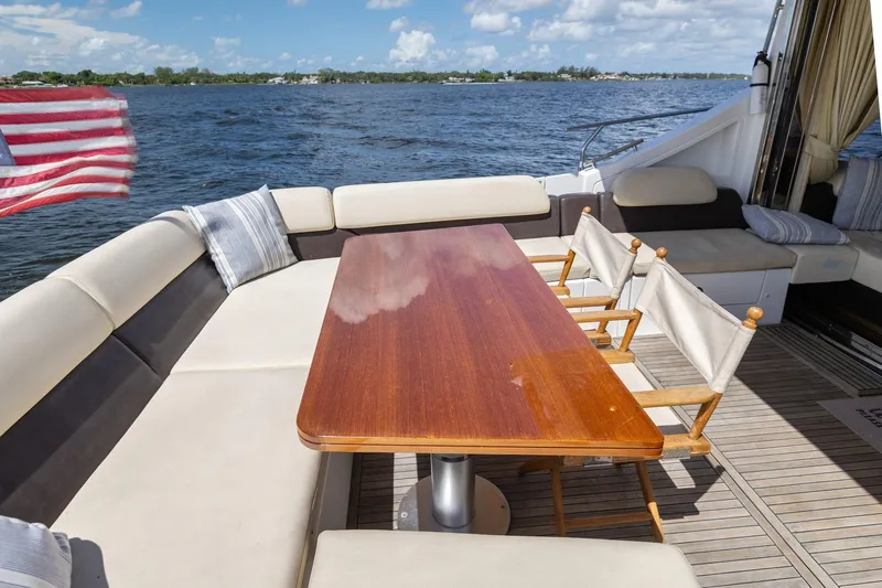 Knot On Call Yacht Photos Pics Luxurious 2015 Azimut 55S yacht deck with seating and table, overlooking serene waters.