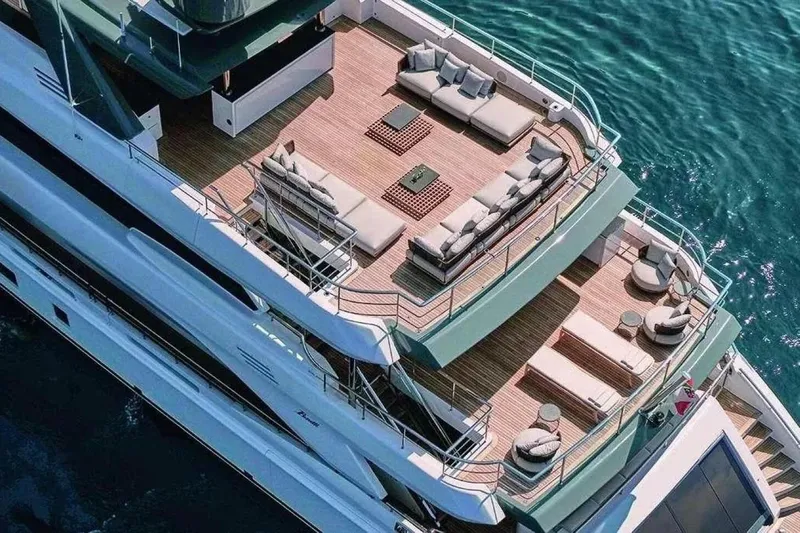 Watercolours Yacht Photos Pics Luxurious 2022 Benetti DIAMOND yacht with elegant deck and seating, cruising on clear blue water.