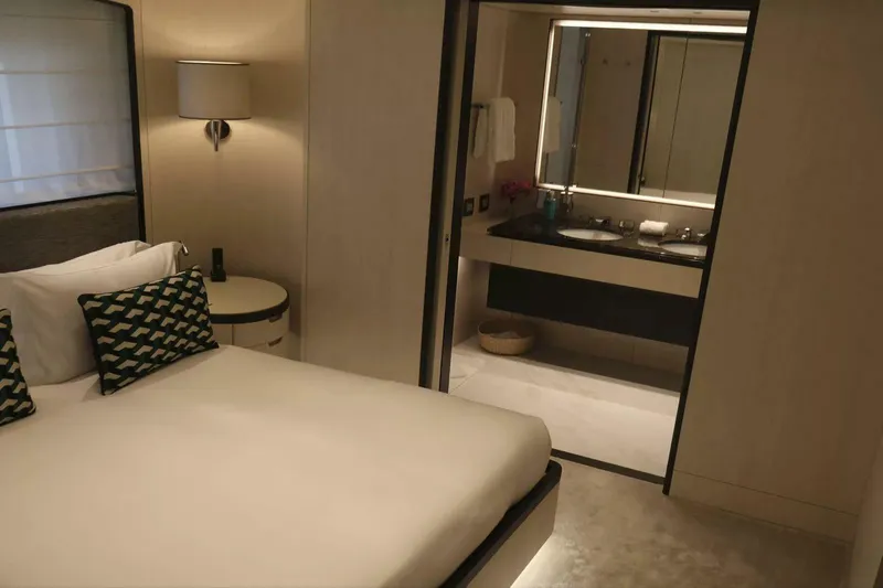 Watercolours Yacht Photos Pics Luxurious Benetti DIAMOND 2022 yacht bedroom with ensuite bathroom, modern decor, and elegant lighting.