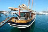 Vintage 1944 Custom Schooner 22 m docked in a marina, surrounded by clear blue water.
