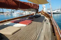 Classic 1944 Custom Schooner 22m with wooden deck and sun loungers in a marina.