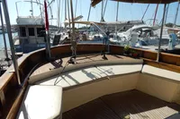 Vintage 1944 Custom Schooner 22 m with elegant wooden deck and seating area in marina.