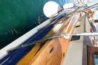 Wooden deck of a 1944 Custom Schooner 22 m, with visible rigging and fenders.