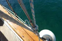 Close-up of a 1944 Custom Schooner's rigging and deck with ocean background.