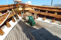 Wooden deck of a 1944 Custom Schooner 22 m with winch and basket.