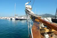1944 Custom Schooner 22 m docked in a marina, surrounded by other boats.