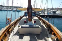 Vintage 1944 Custom Schooner 22 m docked in a marina, showcasing wooden deck and masts.