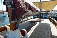 Vintage 1944 Custom Schooner 22 m with wooden deck and sails, docked at marina.
