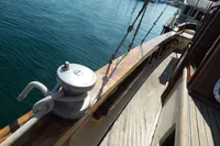Wooden deck of a 1944 Custom Schooner 22 m, featuring nautical rigging and winch.