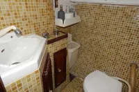 Vintage schooner bathroom with mosaic tiles, compact sink, and toilet, from a 1944 Custom Schooner 22 m.