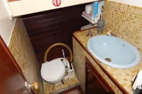 Vintage schooner bathroom with mosaic tiles, compact toilet, and blue sink, Custom Schooner 22 m, 1944.