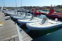 Docked inflatable boats at a marina, sunny day, calm water, 1944 Custom Schooner nearby.